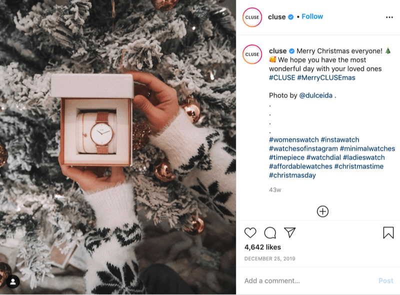 Instagram публикация от @cluse, показваща снимка на модел, облечен в снежинка, който държи часовник пред снежно дърво от @dulceida с хаштаговете #cluse и #meryclusemas