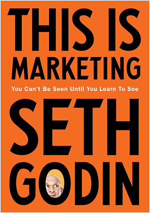 Това е екранна снимка на корицата на This Is Marketing от Сет Годин. Корицата е вертикален правоъгълник с оранжев фон и черен текст. Снимка на главата на Сет се появява в О на фамилията му.