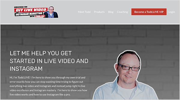 Това е екранна снимка на уебсайта на Тод Бегин. В горния ляв ъгъл е логото на Todd’s, което казва „Направи си сам на живо ВИДЕО И ИНСТАГРАМ МАРКЕТИНГ С Todd“. НА ЖИВО. До този текст има снимка на Тод в лилава риза с копчета и черен суичър с качулка. Вдясно от логото са разположени следните опции за навигация: Meet Todd, Products, Blog, Coaching. След това червен бутон с надпис „Стани Тод. LIVE VIP ”се появява. Вдясно от бутона се появява опция за вход. Под заглавката и навигацията има снимка на Тод, очертана в бяло на фона на сиво боядисана тухлена стена. Тод е с очила и светлосиня риза с копчета, отворена на яката с бяла тениска отдолу. Той е усмихнат и носи очила с черни рамки. Вляво от това изображение е следният текст: „Позволете ми да ви помогна да започнете с видеоклипове на живо и Instagram“ и „Здравей, аз съм Тод. НА ЖИВО! Тук съм, за да ви покажа чрез собствените си опити и грешки как точно можете да спрете да губите време, опитвайки се да разберете извадете всичко видео на живо и Instagram и вместо това скочете направо към съвършенство на видео на живо и Instagram майсторство. Тук съм, за да ви покажа как работи видеото на живо и как да използвате Instagram като професионалист. "
